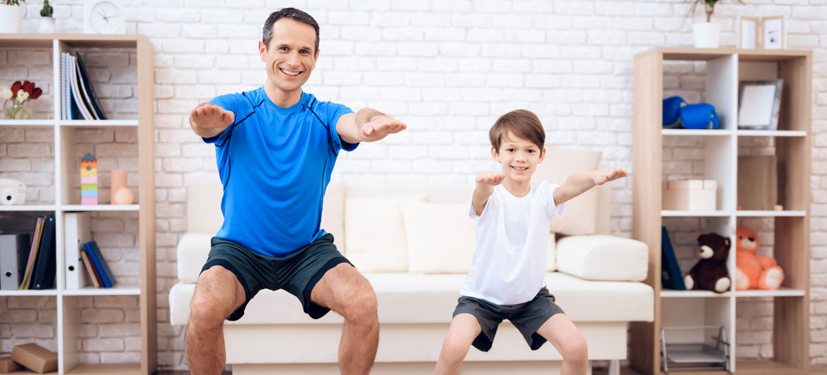 Adult și copil făcând exerciții fizice acasă